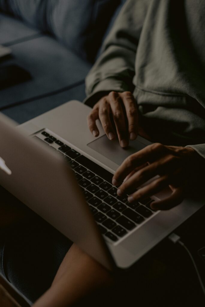 Close-up of hands typing on a laptop indoors, perfect for work-from-home themes.